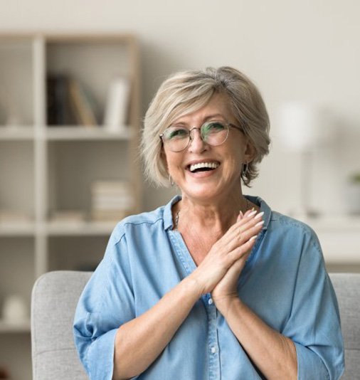 a woman smiling while sitting at home