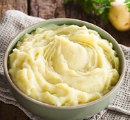 a bowl of mashed potatoes on a wooden table