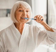 a woman brushing her teeth at home