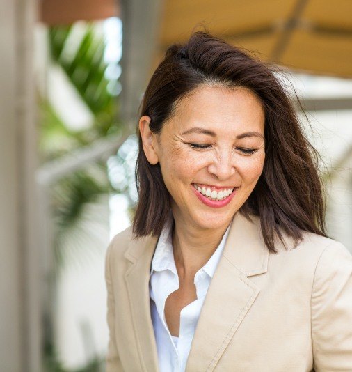 Woman with complete smile after dental implant tooth replacement