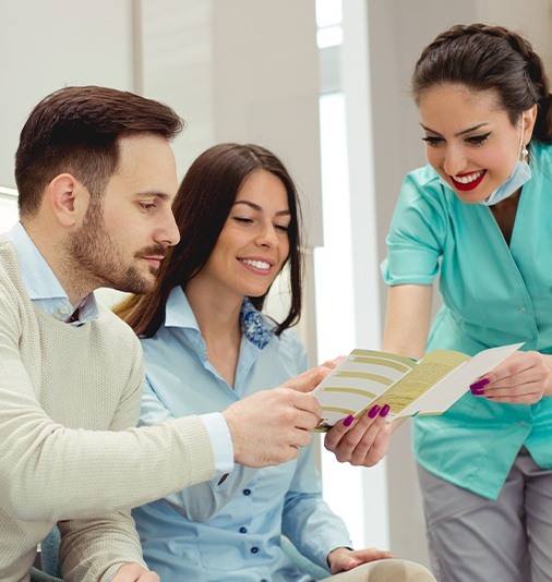 Team member and patients reviewing dental insurance information