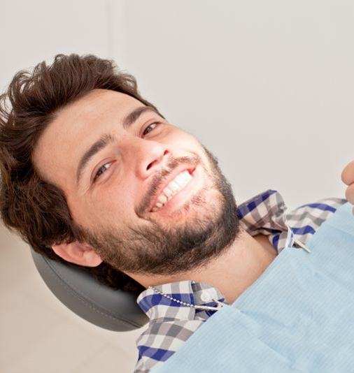 Patient in treatment chair, giving thumbs up gesture