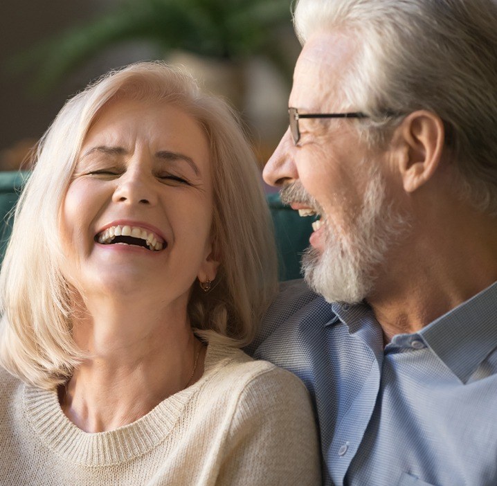 Man and woman sharing healthy smiles after periodontal therapy
