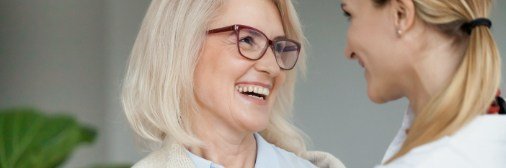 Woman smiling at team member at surgical periodontal treatments